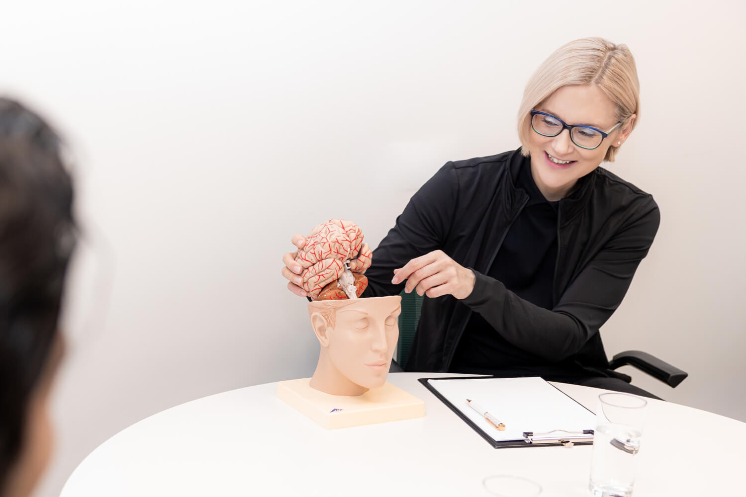 Dr. Katrin Kiehl erklärt ein Modell mit einem Gehirn