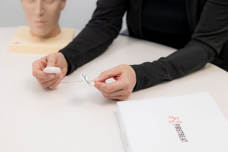 Person zeigt Firstbeat-Sensor zur Messung von Stress und Herzfrequenz.