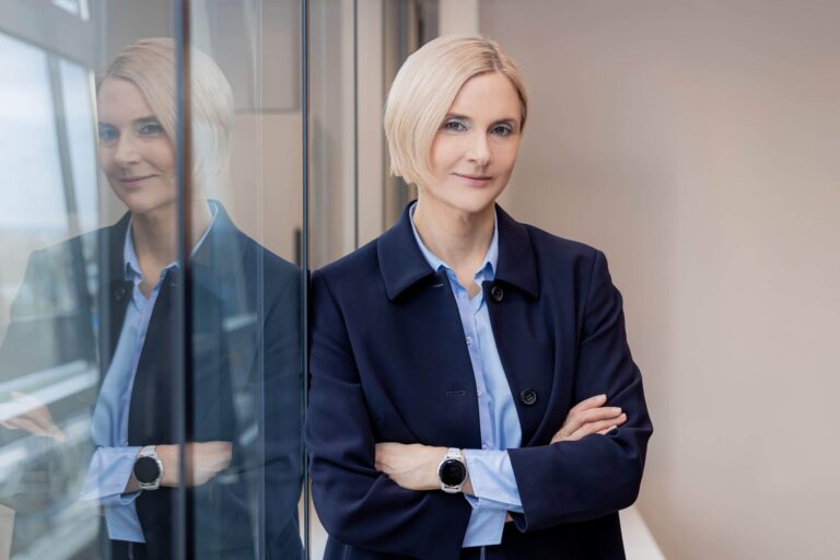 Frau Dr. Katrin Kiehl lehnt an einer Glaswand mit verschränkten Armen